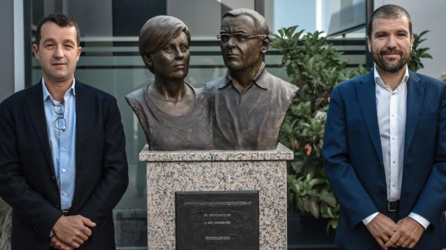 Ángel (a la izquierda) y José Escribano, en la sede del grupo, con un busto dedicado a sus padres.