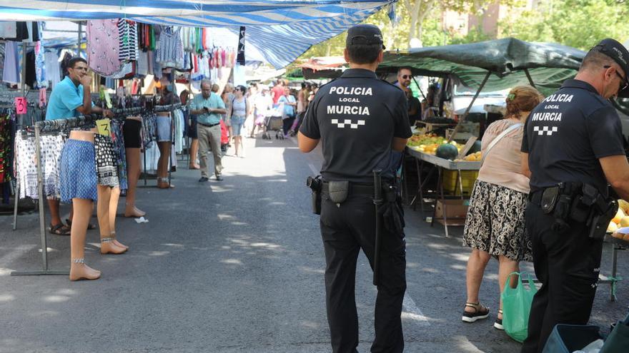 Dos agentes de la Policía Local de Murcia patrullan por un mercado de la capital.