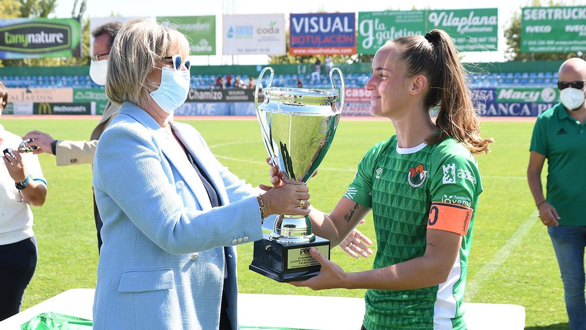 Entrega del trofeo de campeona a la capitana cacereña, Nerea, por parte de Ángeles Aguilera, vicepresidenta de la Federación Extremeña de Fútbol.