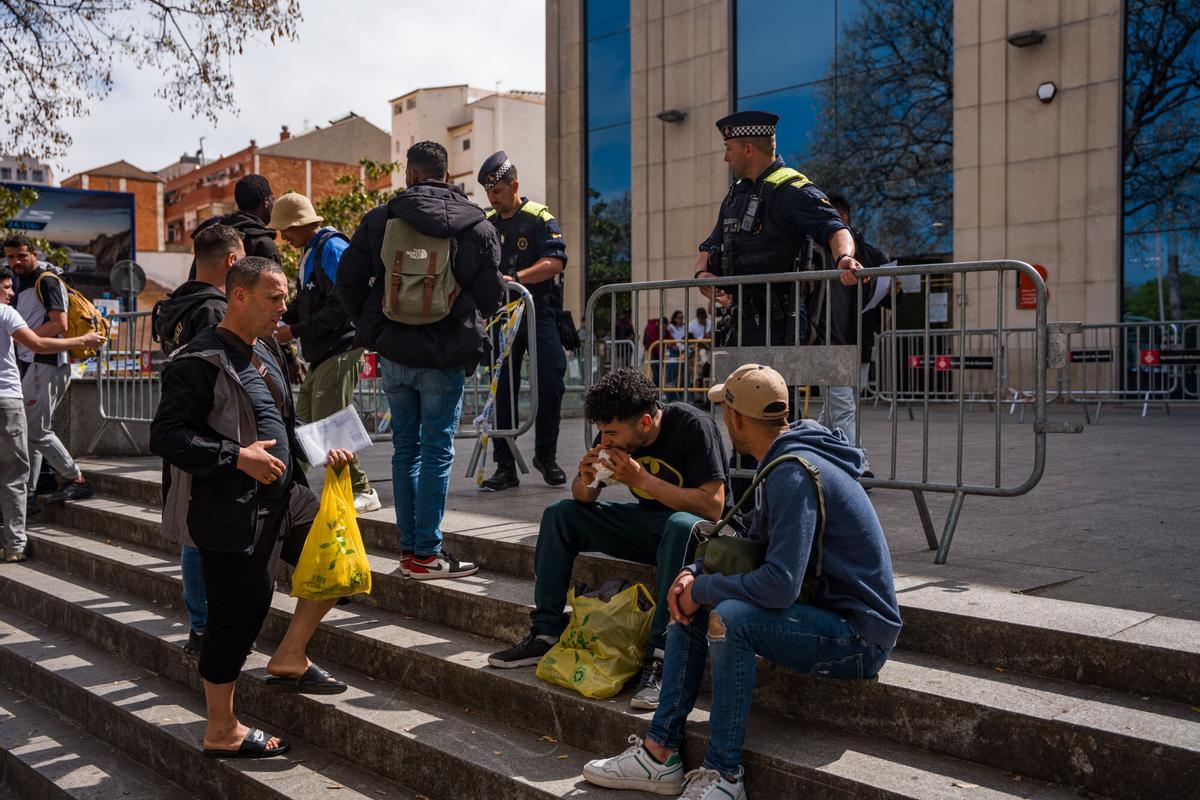 Caos y una larga cola de personas que esperan regularizar su situación en España en la Oficina de Benestar Social i Família de Barcelona-Sants/Eixample.