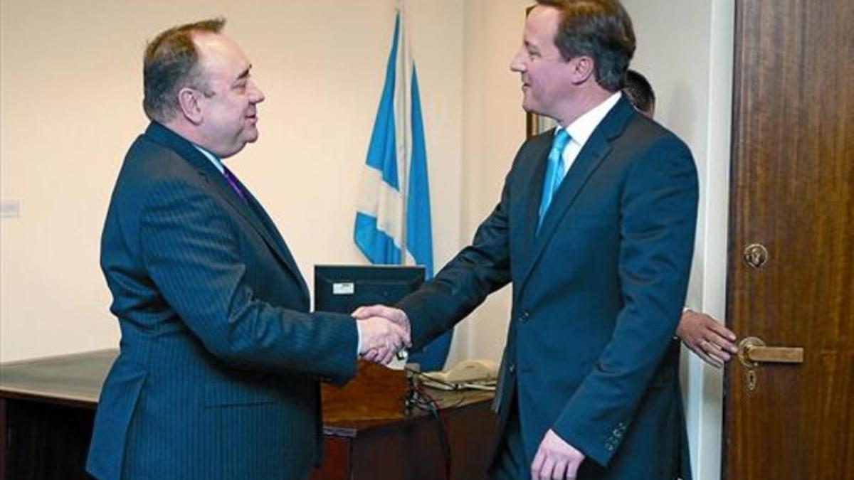 El ministro principal de Escocia, Alex Salmond (izquierda) estrecha la mano del 'premier' británico, David Cameron, ayer en Edimburgo.