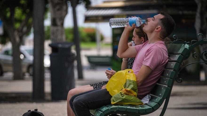 Un hombre bebe agua para paliar los efectos del calor.