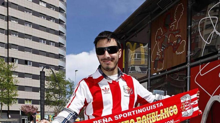 Álex Varela con su bastón, su camiseta del Sporting y la bufanda de la peña Sentimiento Rojiblanco.