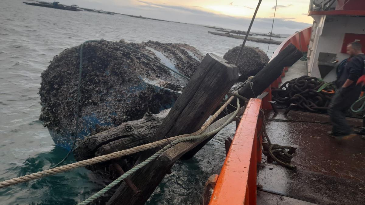 La recuperación de los restos de una batea destrozada por el temporal, remolcados a tierra por el barco &quot;Cuico&quot;, de Dragados Osmar.