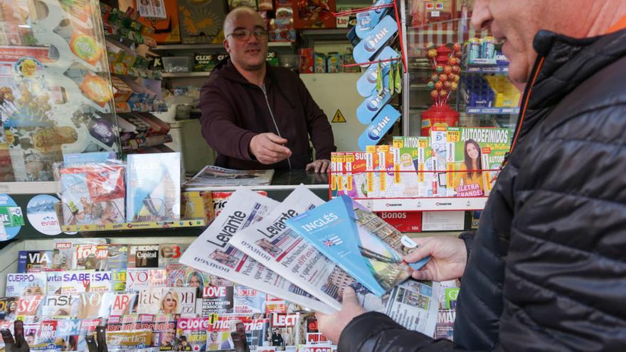 Una persona compra el periódico en Valencia.