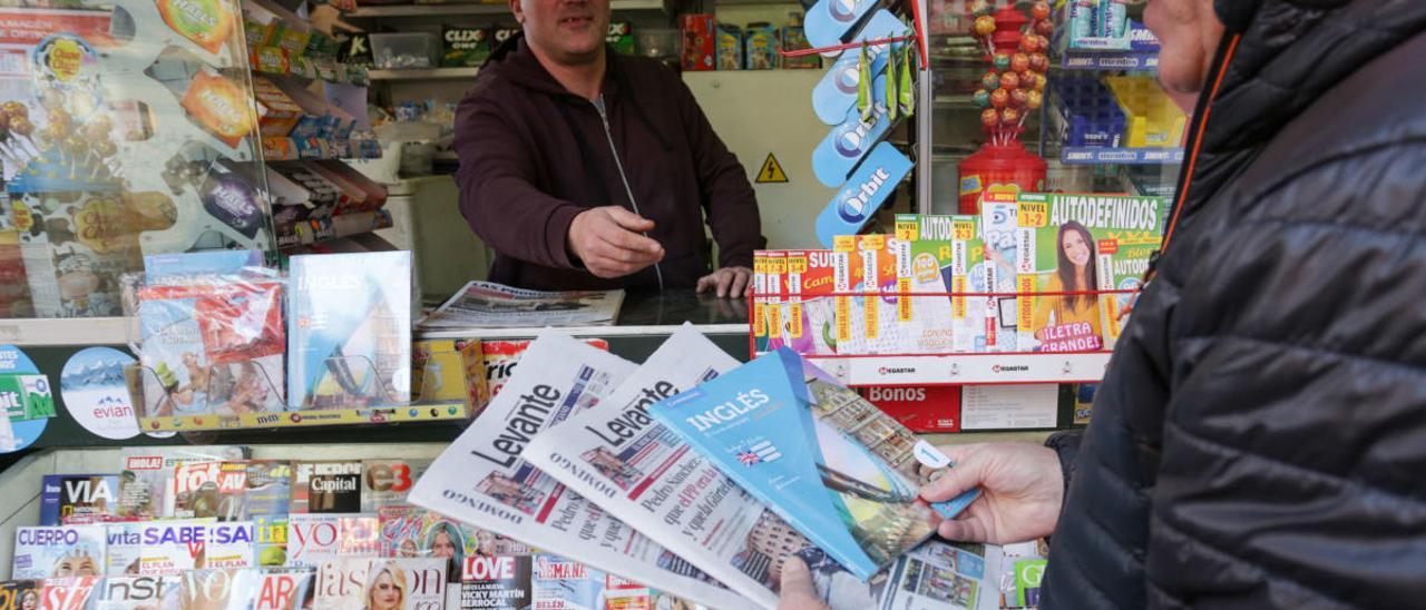 Una persona compra el periódico en Valencia.