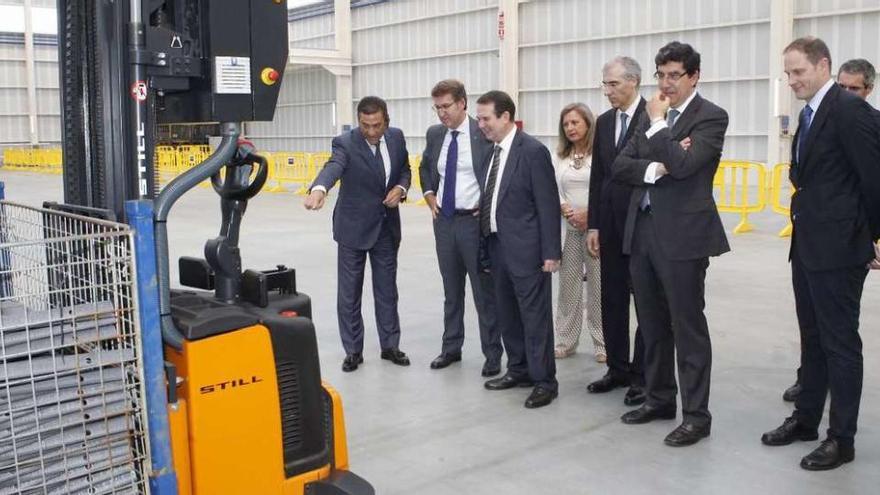 Ricardo García, Feijóo, Caballero, Pedrosa, Conde, López-Chaves, Yann Martin y Aibéo observan uno de los nuevos vehículos de guiado automático (AGV) en la nueva nave de Benteler en Vigo. // Ricardo Grobas