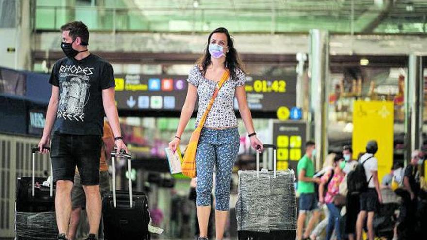 Una pareja de turistas británicos a su llegada al aeropuerto del sur de Tenerife. | | ANDRÉS GUTIÉRREZ