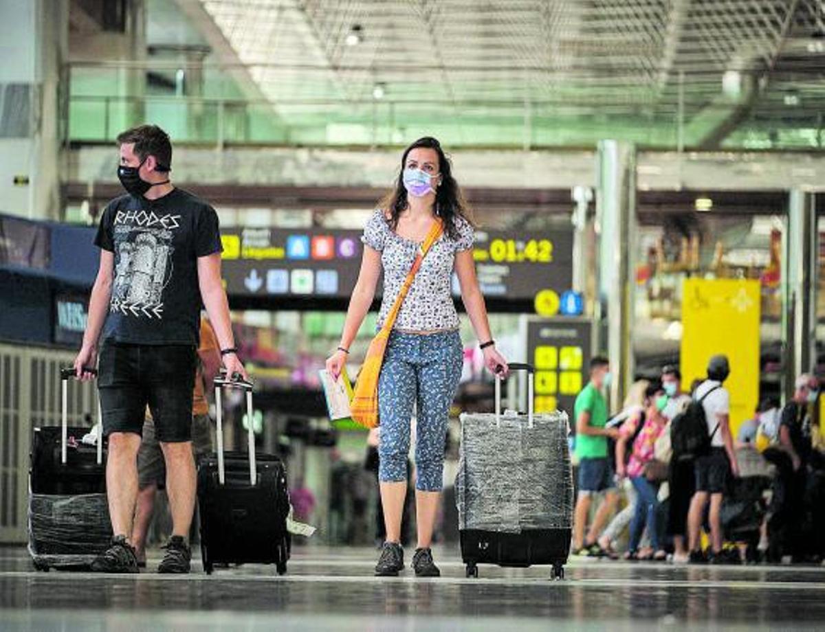 Una pareja de turistas británicos a su llegada al aeropuerto del sur de Tenerife. | | ANDRÉS GUTIÉRREZ
