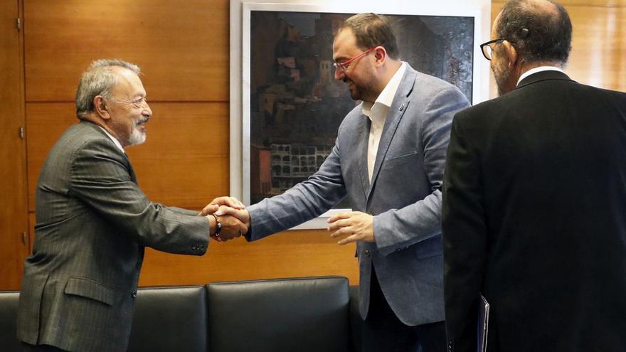 Adrián Barbón estrecha la mano a Carlos González Pintado, en presencia del escritor Jesús Sáez Carreras, ayer. | Gobierno de Asturias