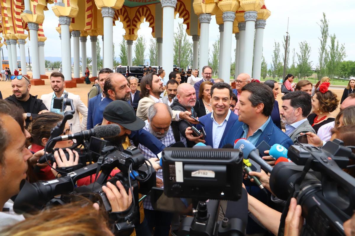 Melé de periodistas en torno al candidato José María Bellido y el presidente andaluz, Juanma Moreno.