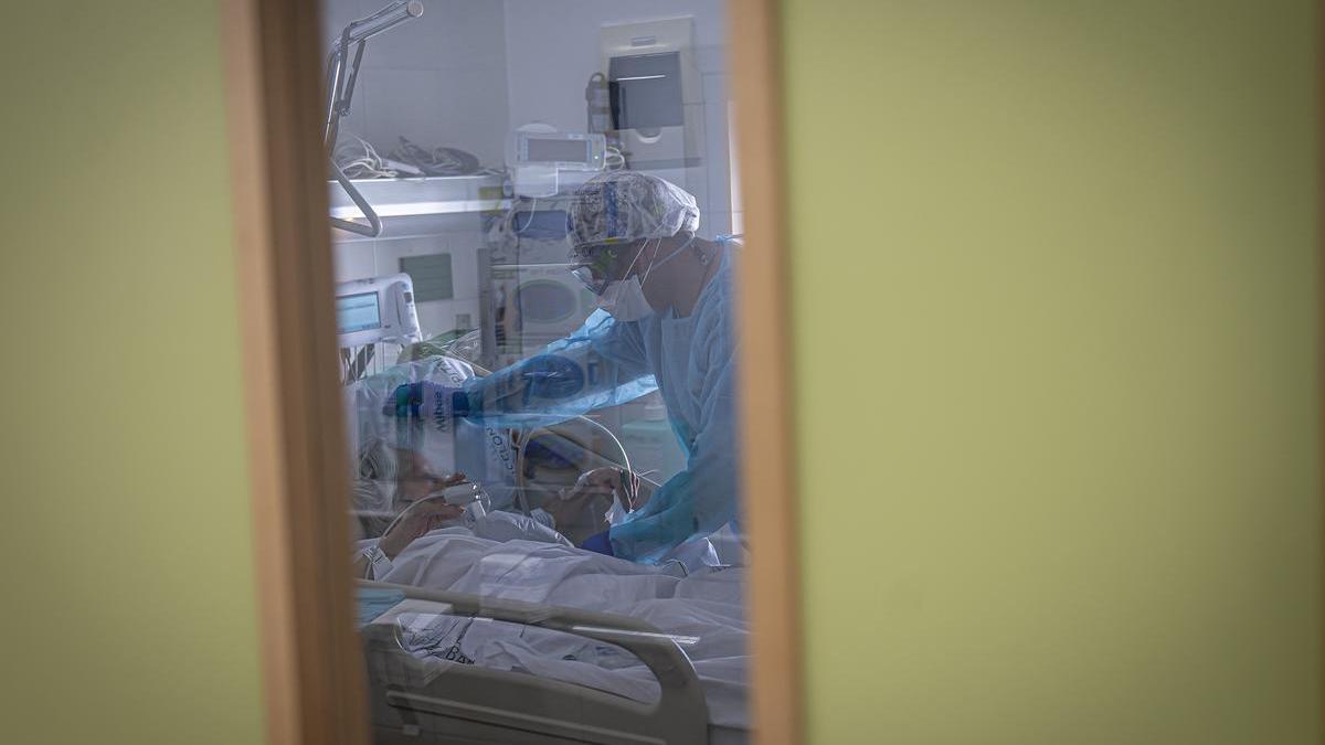 Una sanitaria del Hospital Clínic de Barcelona atiende a un enfermo durante la pandemia de covid-19.