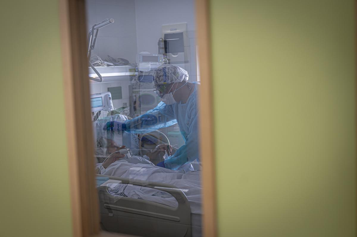 Una sanitaria del Hospital Clínic de Barcelona atiende a un enfermo durante la pandemia de covid-19. Manu Mitru
