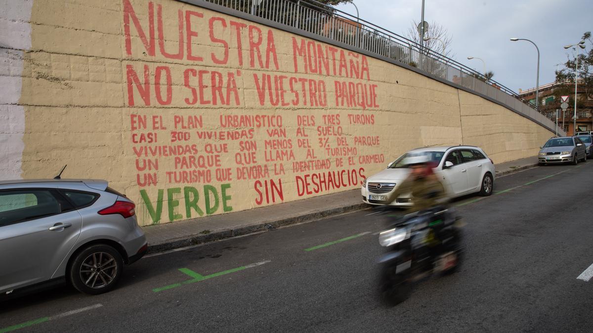 Pintada crítica con el plan urbanístico de los Tres Turons que completa el grafiti de Blu en el Carmel.