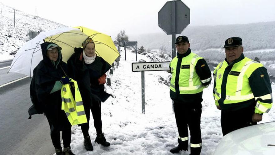 Agentes de Guardia Civil de Tráfico de Verín reparten chalecos a peregrinos en el alto de A Canda (Ourense).