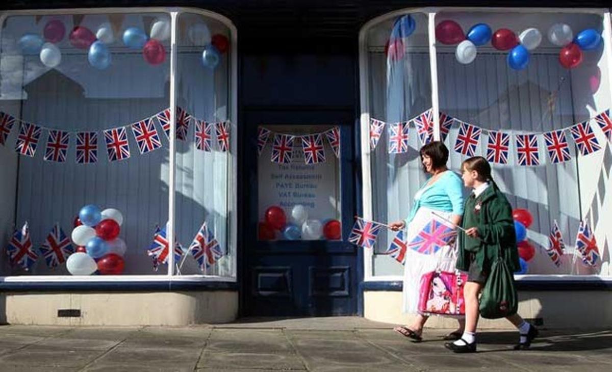 Dues persones es preparen per aconseguir una bona posició per veure la visita de la Reina Isabel II d’Anglaterra i el príncep Felip, duc d’Edimburg, a Alnwick, Anglaterra.
