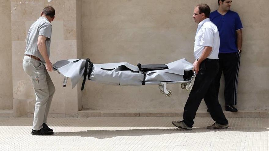 Empleados de la funeraria trasladan el cadáver de la víctima, el 2 de mayo de 2014 en Campos.