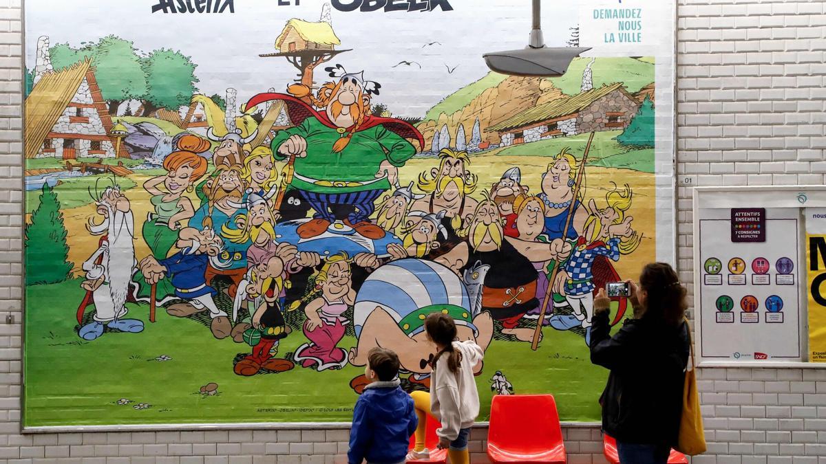 Niños mirando un cartel del 60 aniversario de Astérix y Obélix, en 2019, en la Gare de Lyon de Paris.