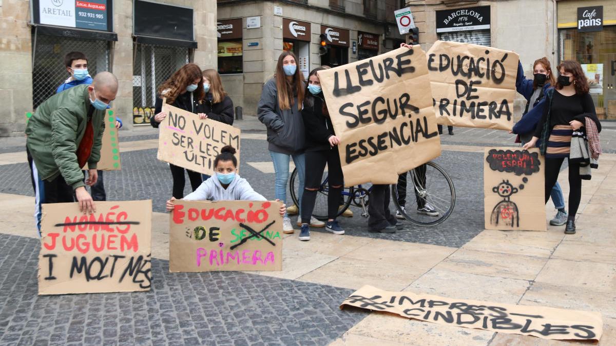 Pla conjunt de diversos joves amb pancartes a plaça Sant Jaume de Barcelona, aquest dissabte 20 de febrer.