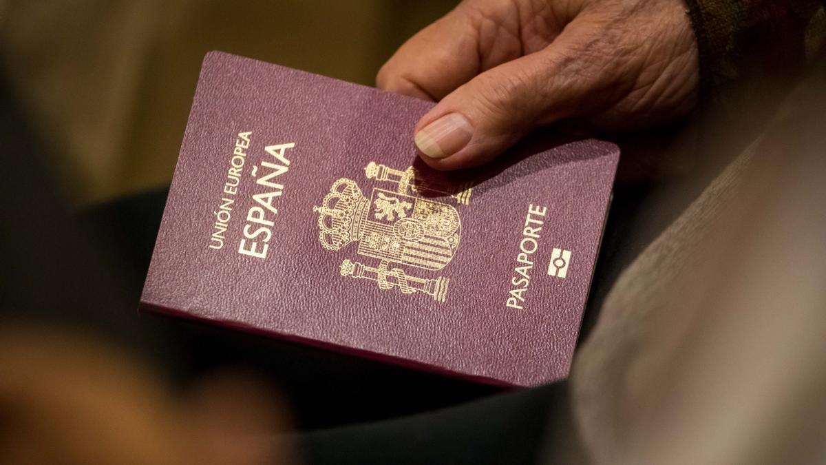 Una mujer sujeta un pasaporte español.