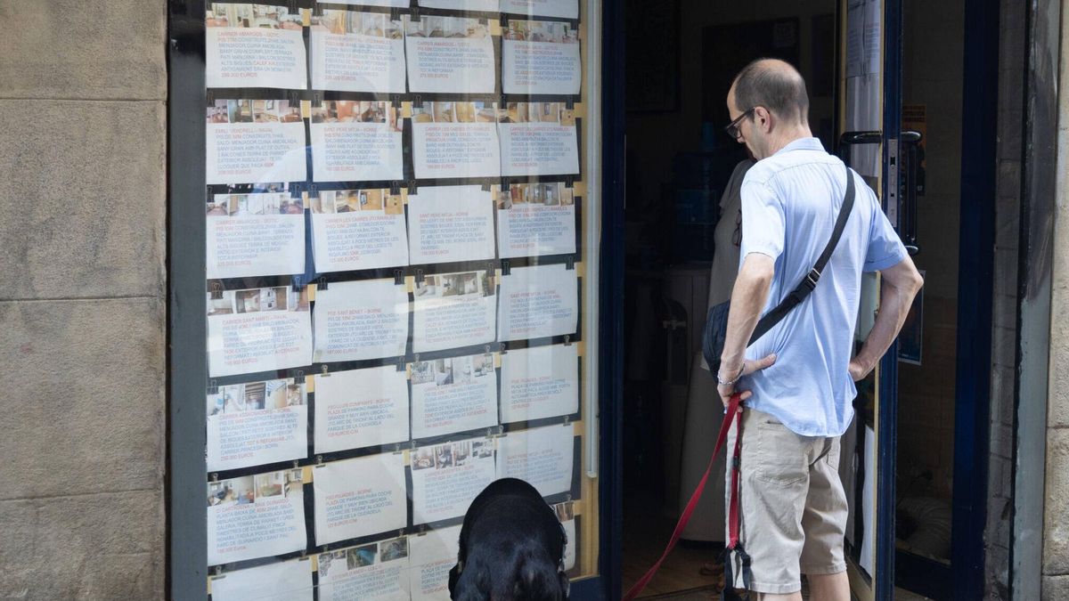 Un hombre mira la oferta de una inmobiliaria en Barcelona.