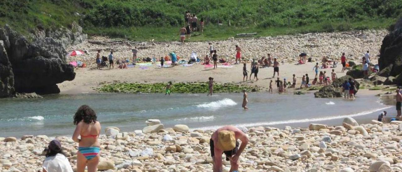 Bañistas en la playa de Cuevas del Mar, en Llanes.