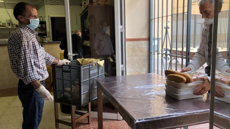 Un voluntario de Ángeles Malagueños de la Noche entrega la comida a un usuario.