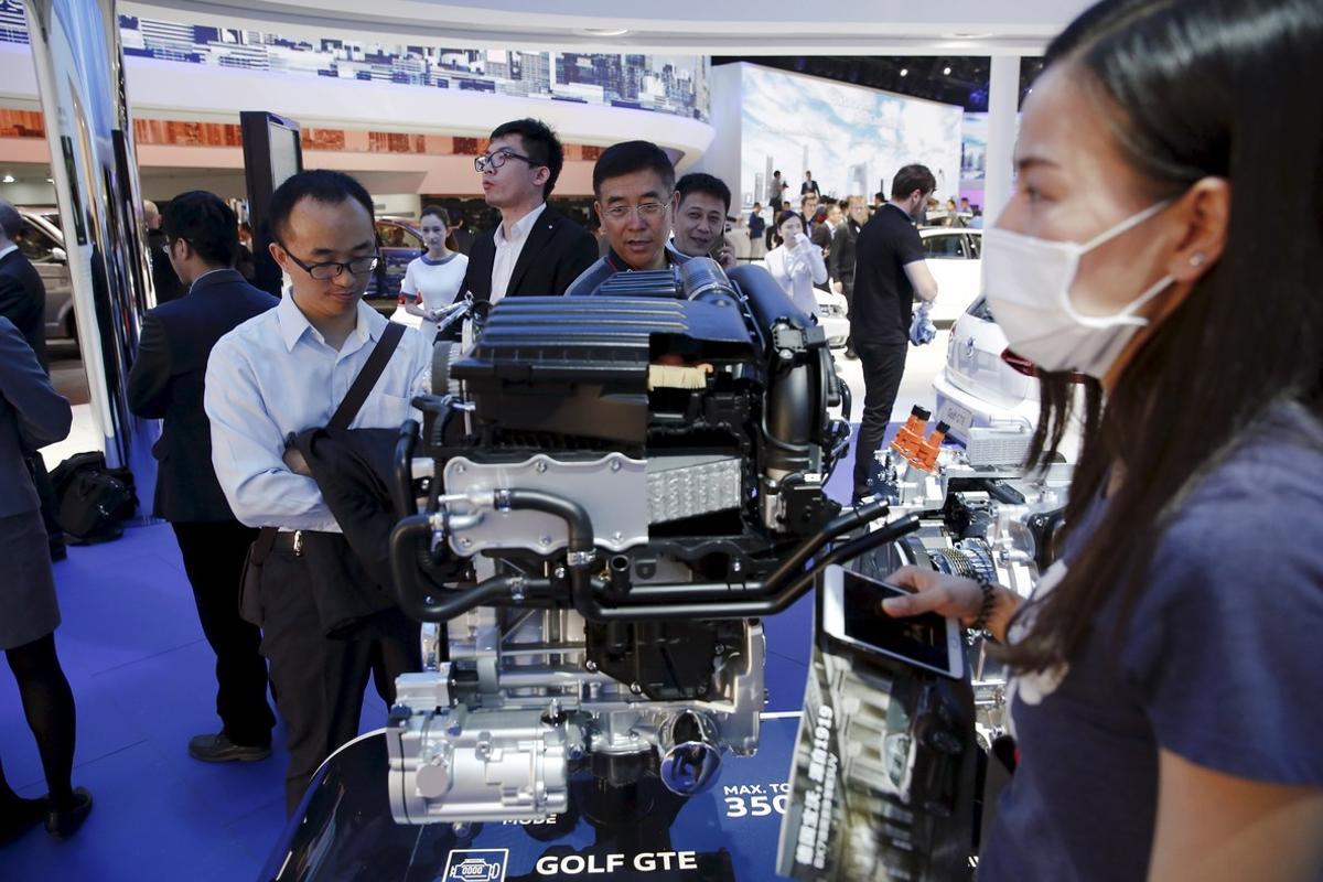 Un grupo de visitantes observa un motor de Volkswagen en el Salón del Automóvil de Pekín.