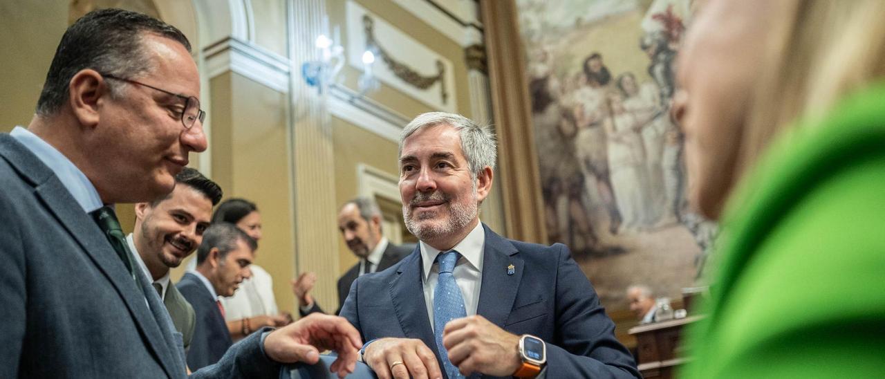 El presidente Fernando Clavijo conversa con el consejero Poli Suárez antes del pleno del Parlamento.