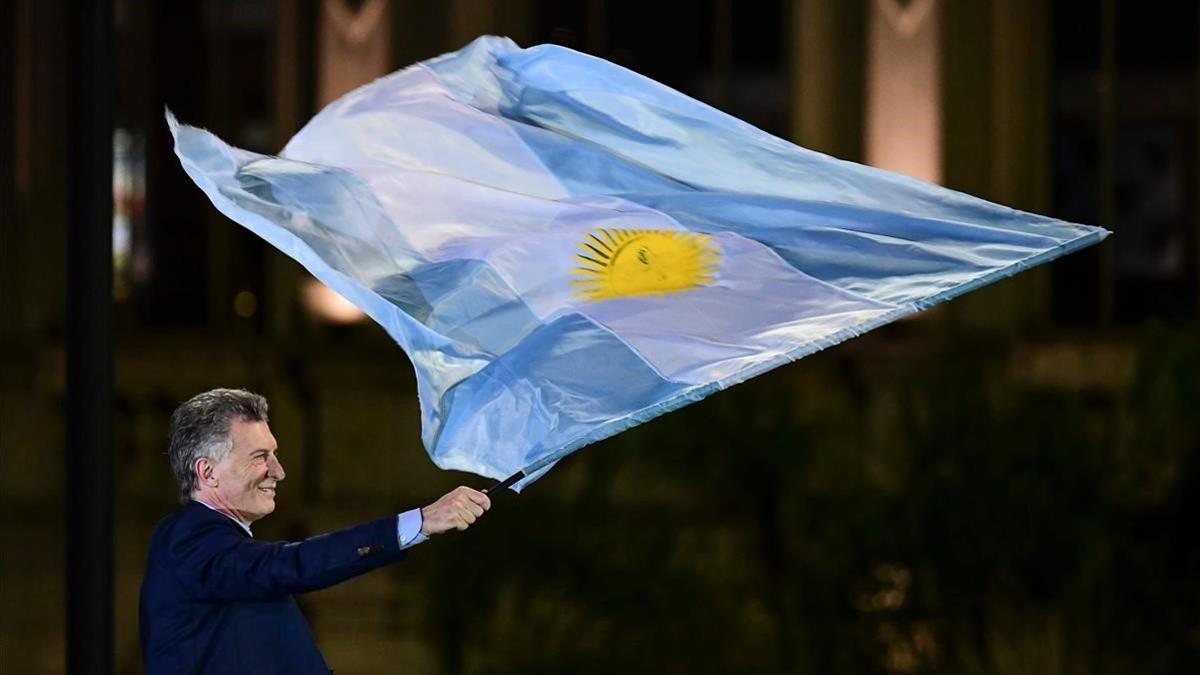 Macri ondea una bandera argentina en el mitin de clausura de su campaña electoral, en Córdoba.