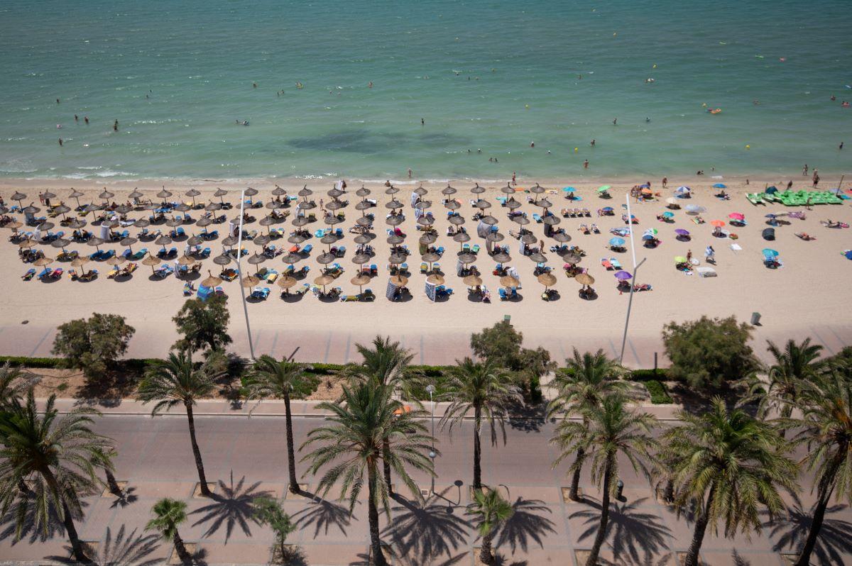 Badegäste an der Plata de Palma auf Mallorca an einem warmen Sommertag.