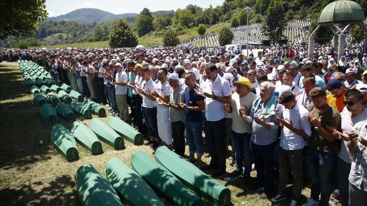 Familiares de víctimas rezan junto a los féretros con restos de las víctimas de Srebrenica identificadas en el 2017.