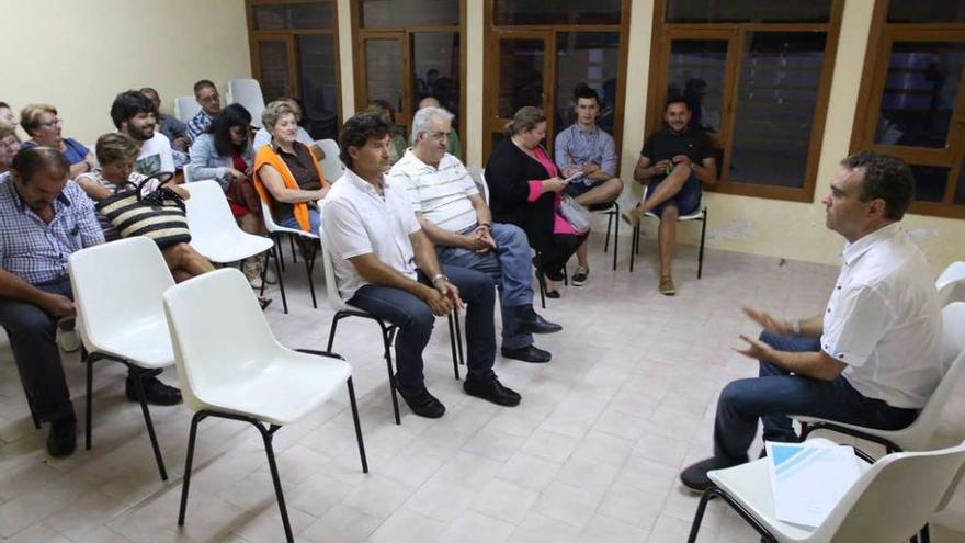 Iván Fernández, a la derecha, se dirige a los vecinos de Solís en las antiguas escuelas de la parroquia.