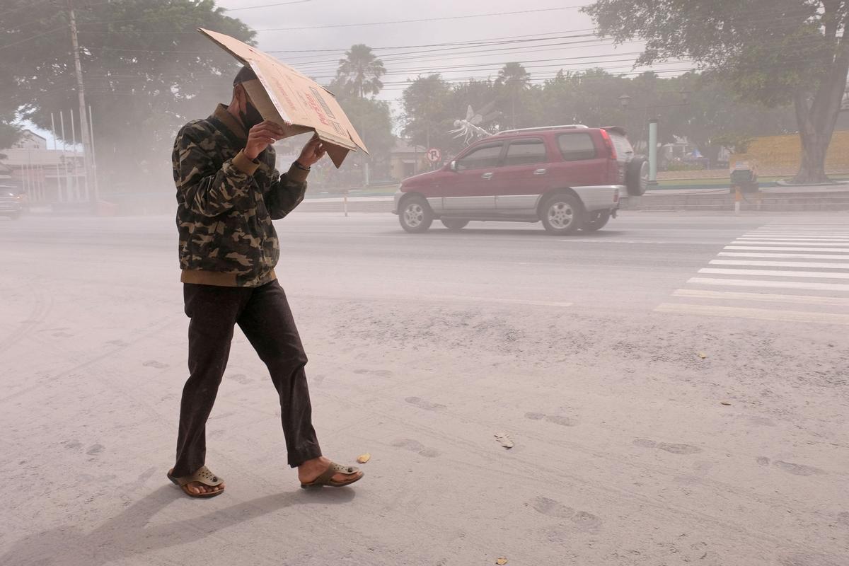 Un hombre usa cartón para protegerse de las cenizas de la erupción del volcán Monte MerapiÊ de Indonesia, en Magelang, provincia de Java Central.