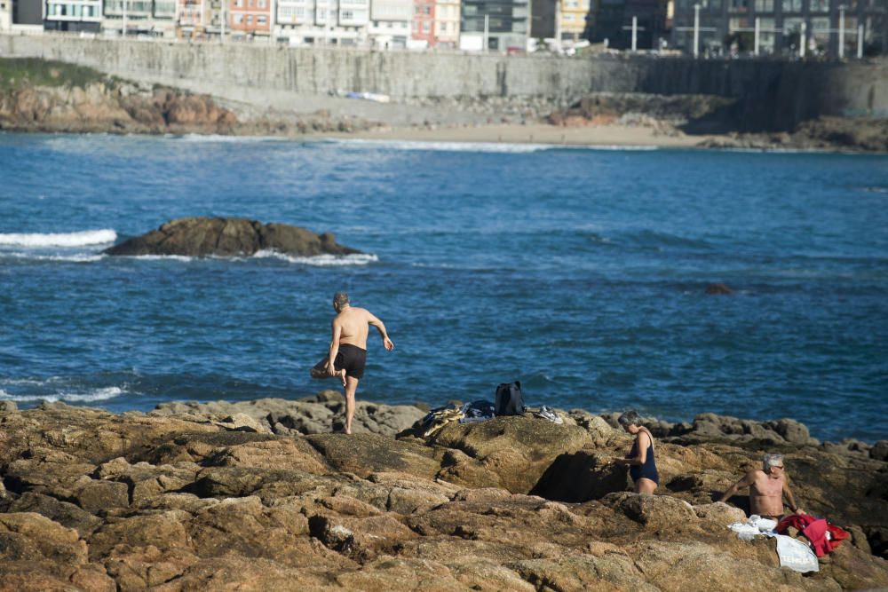 Bañistas en otoño en la playa de Riazor