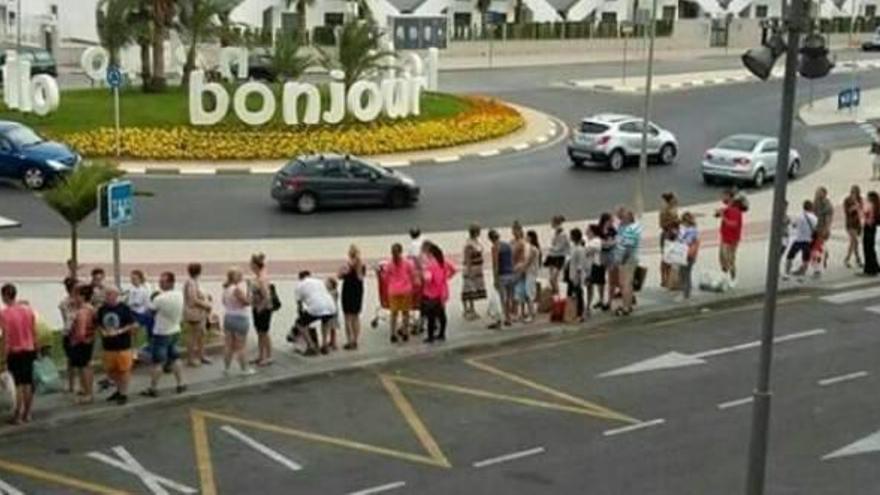 Numerosos usuarios esperan cada día de verano junto a un centro comercial de la costa para poder coger un taxi.