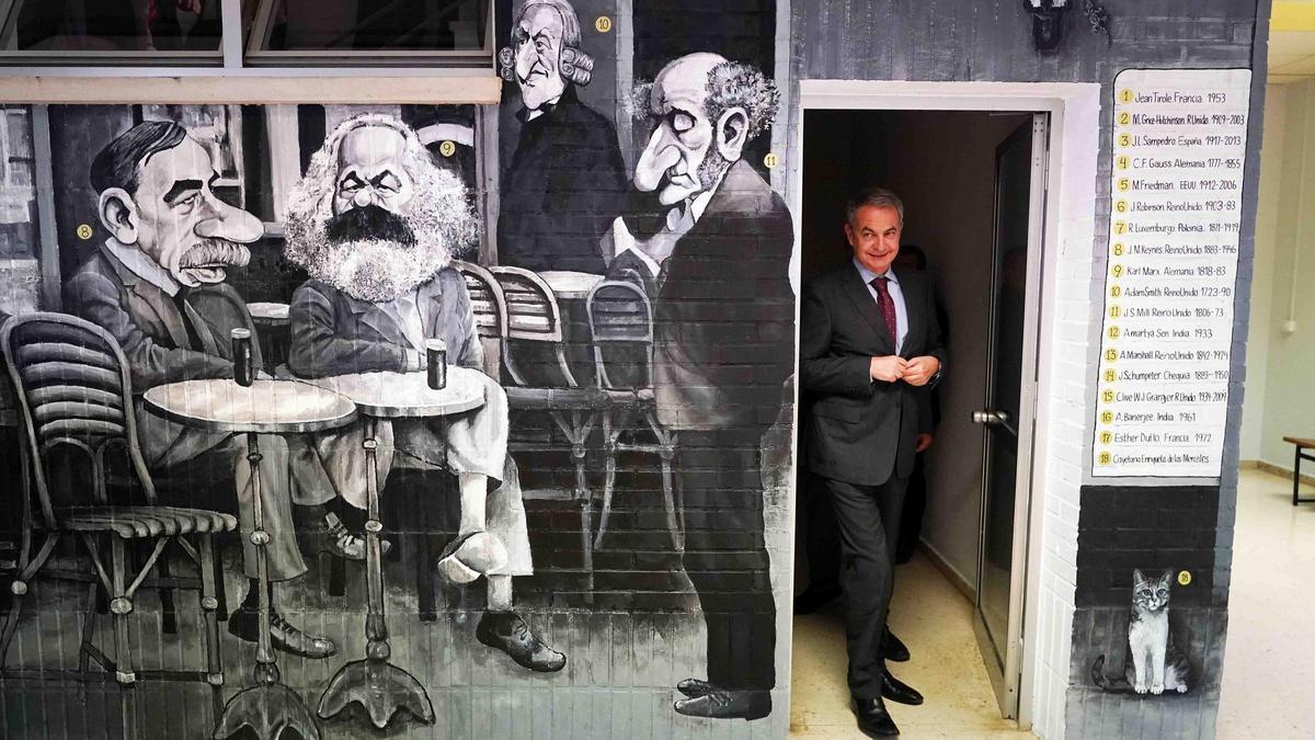 El expresidente del Gobierno José Luis Rodríguez Zapatero pasa junto al mural de Idígoras en la Facultad de Económicas y Empresariales.