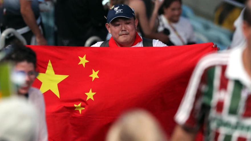 Un aficionado chino con la bandera nacional de su país.