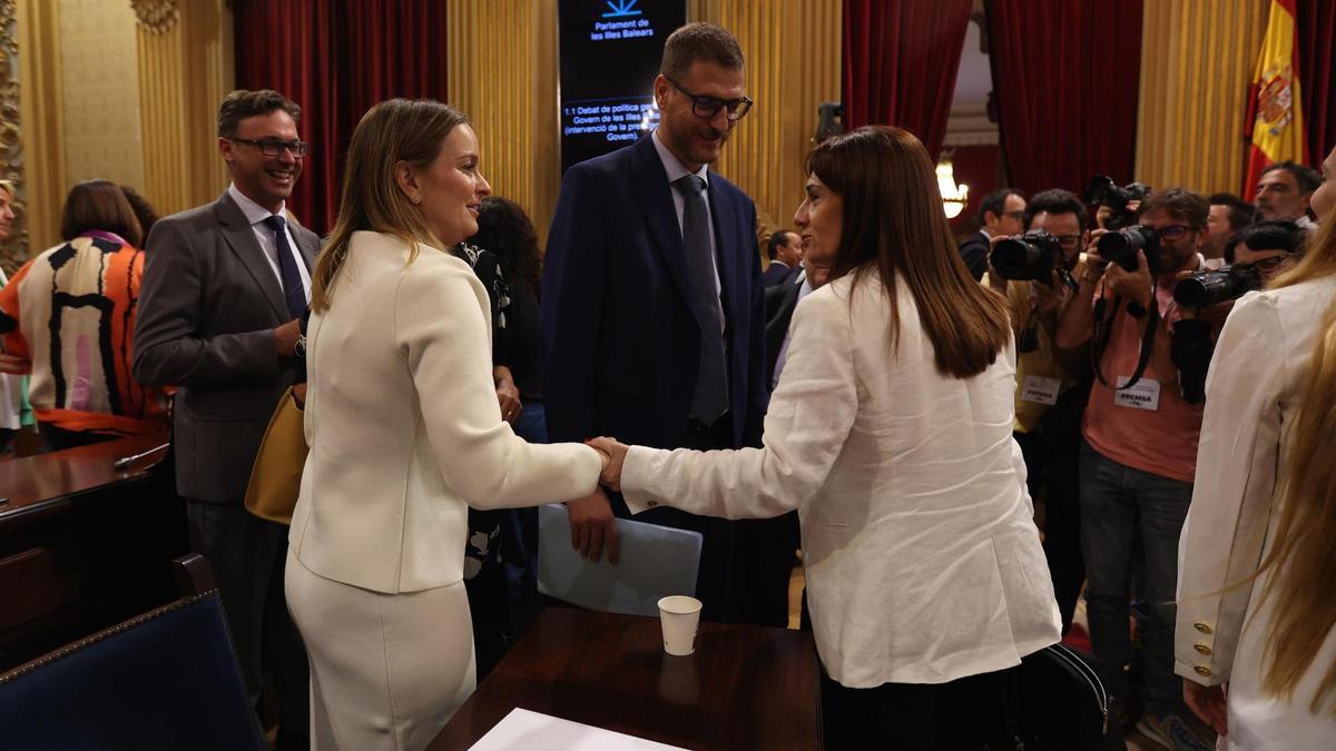 La presidenta del Govern, Marga Prohens (i), saluda a la portavoz de VOX en el Parlament balear, Manuela Cañadas (d), en un pleno
