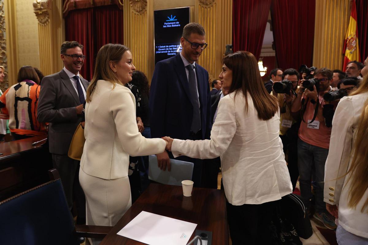 La presidenta del Govern, Marga Prohens (i), saluda a la portavoz de VOX en el Parlament balear, Manuela Cañadas (d), en un pleno.
