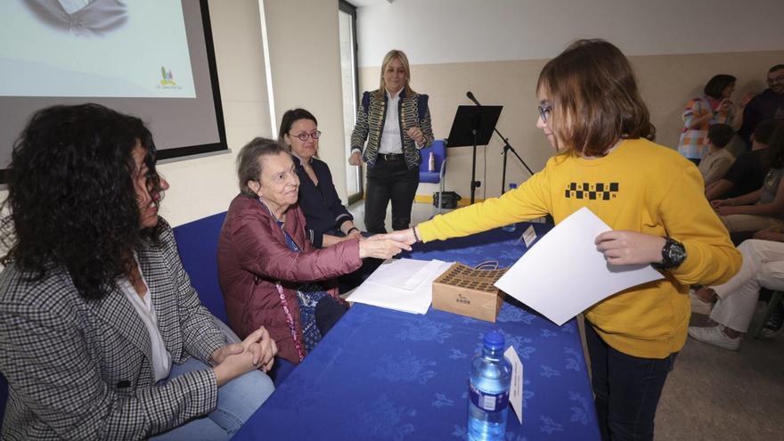 Mateo Tuñón recibe el diploma de manos de Carmen Ruiz-Tilve.