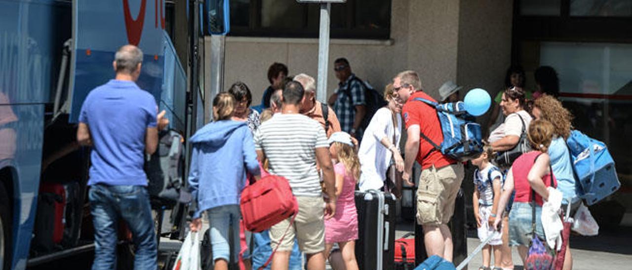 Turistas, ayer junto a una guagua en el aeropuerto de Gran Canaria.