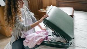 Una mujer cerrando su maleta.