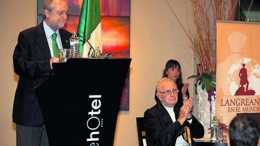 Carlos Suárez Nieto agradece el premio «Langreanos en el Mundo» 2011, con José Ramón González, «Monxu», sentado.