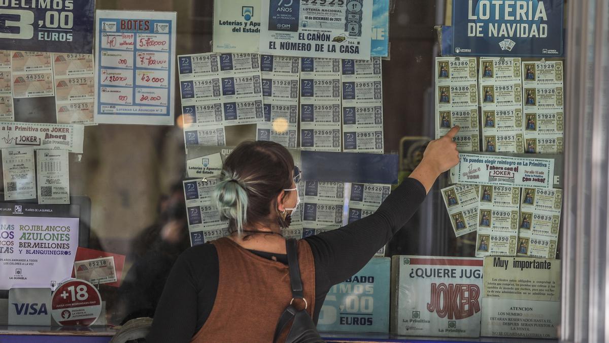 Una mujer señala un décimo en la administración número 2 de Elche.