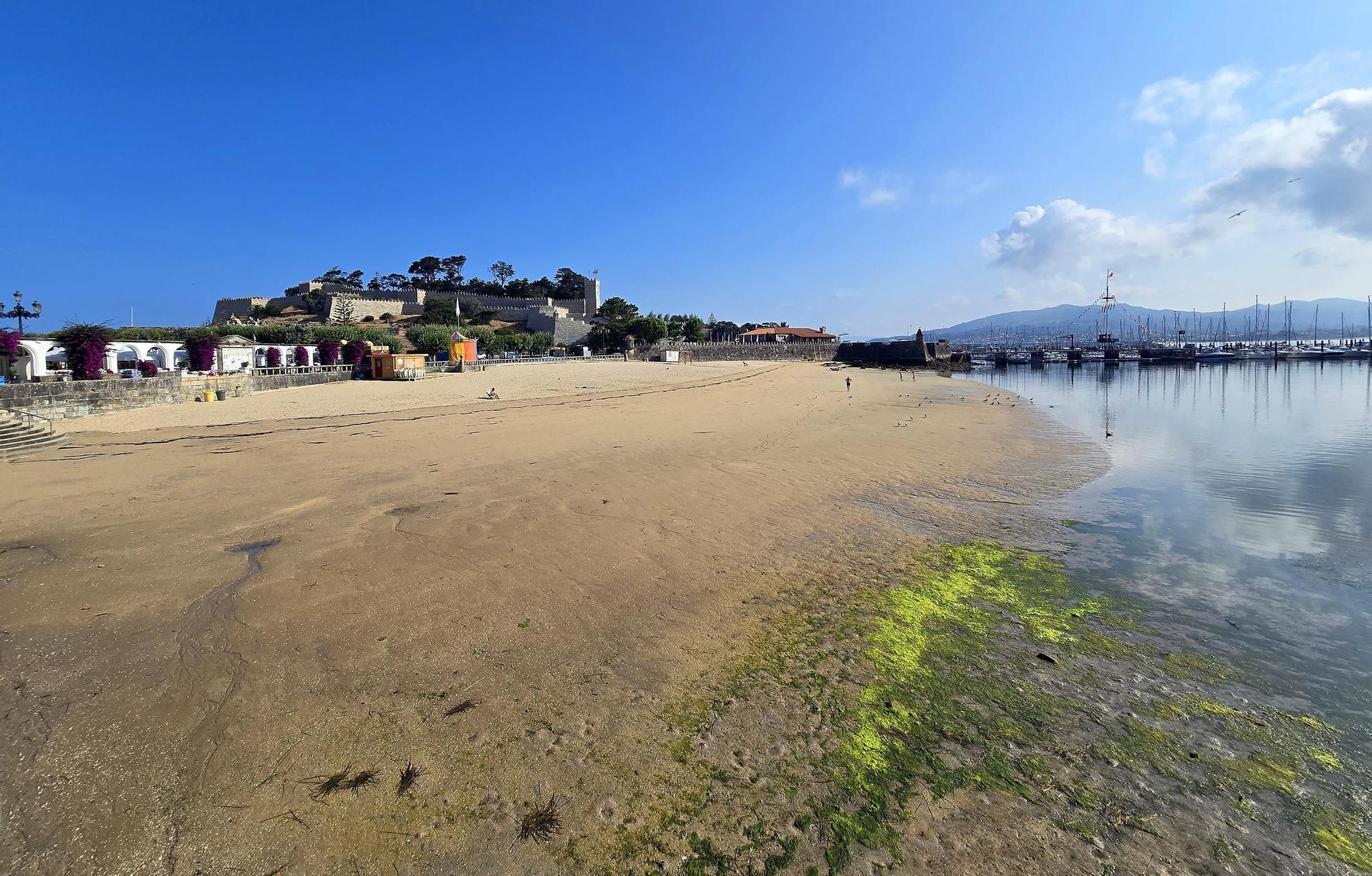 Vista de la playa de A Ribeira vacía y con bandera roja por la contaminación del agua