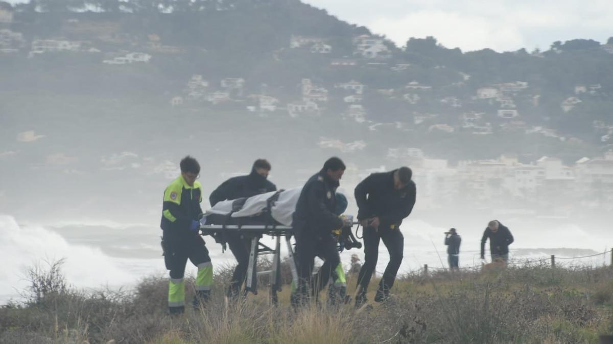 Los sanitarios y los agentes llevan en camilla al surfista accidentado