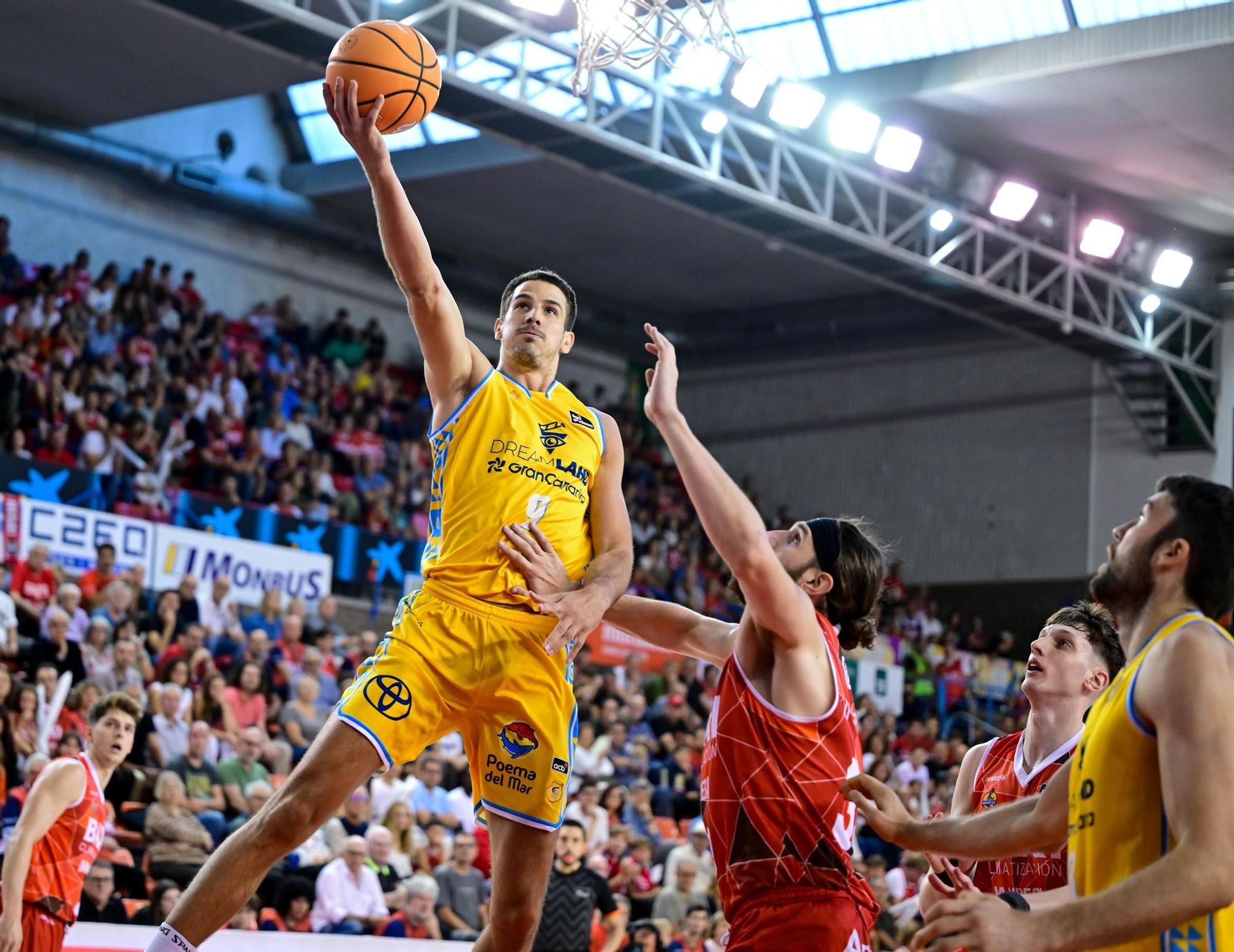 Brussino busca finalizar una bandeja ante la defensa de Grant Golden.