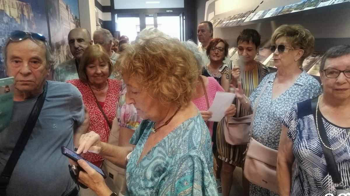 Persones esperant torn a l'interior de l'Oficina de Turisme de Manresa, dilluns al matí