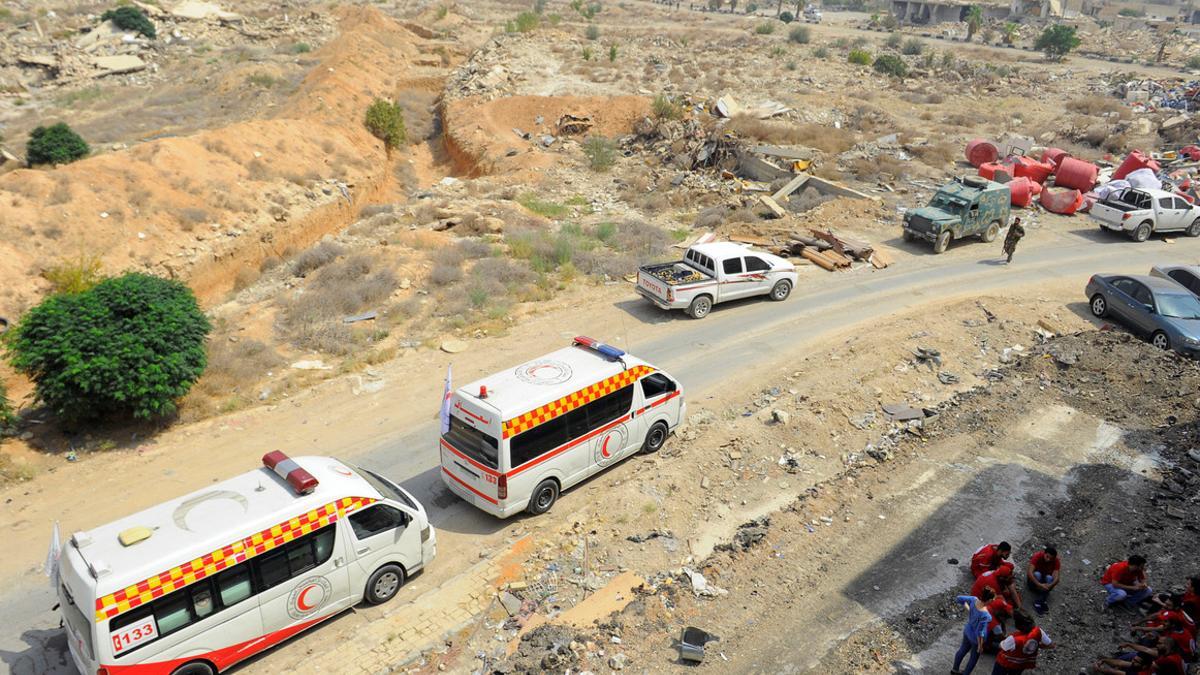 A Syrian Arab Red Crescent convoy waits at the entrance of the besieged Damascus suburb of Daraya, before rebels and residents start being evacuated under an agreement reached on Thursday between rebels and Syria's army